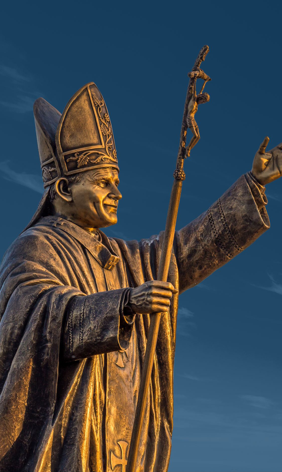 Large bronze statue of Pope St. John Paul II with one arm outstreched and another holding a staff.