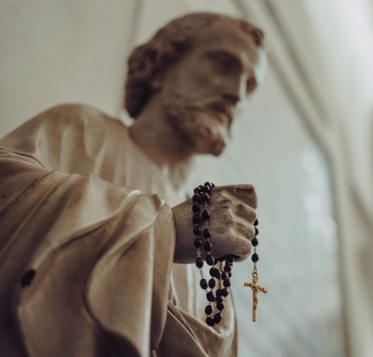 Statue of St. Joseph holding a rosary.